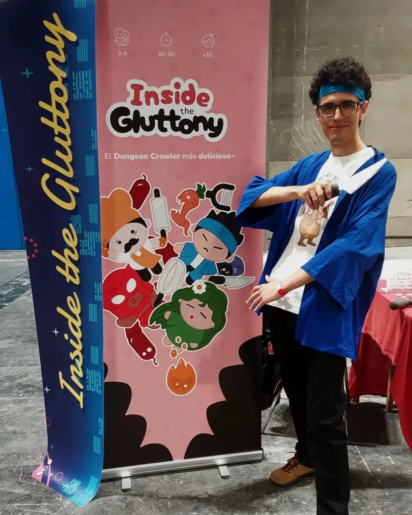 Foto en un evento de Raúl Revilla, junto con el roll-up del juego.